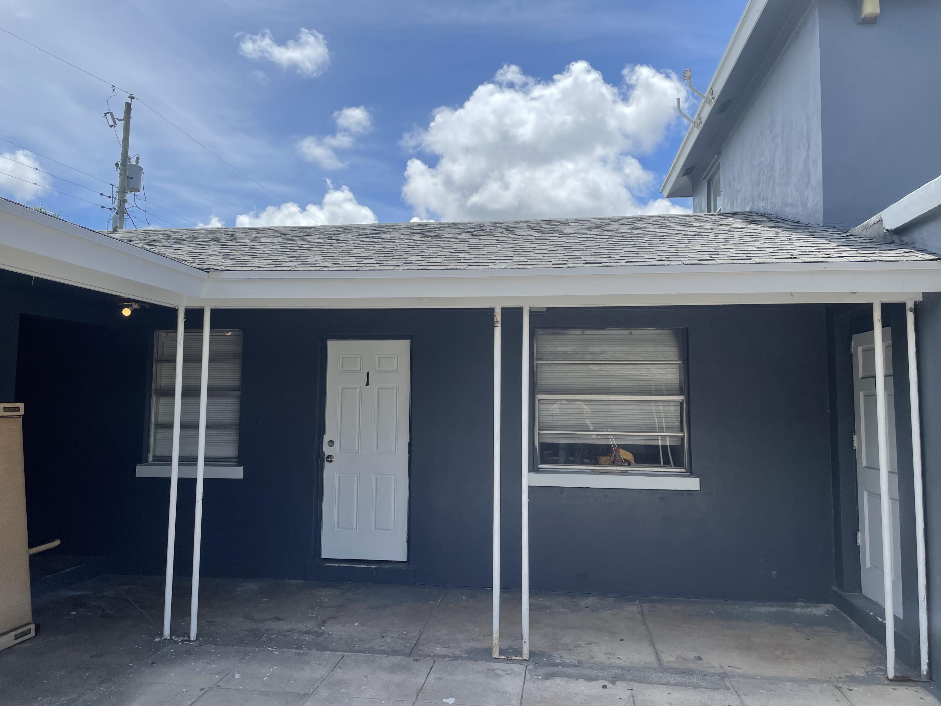 131 East 27th Street, Unit 1 Riviera Beach, FL 33404 - Photo 10 of 10 a kitchen with kitchen island granite countertop a refrigerator and microwave