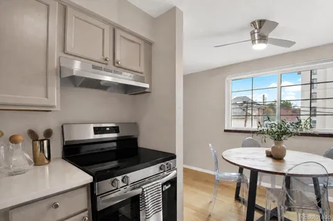 a kitchen with stainless steel appliances a table chairs and cabinets