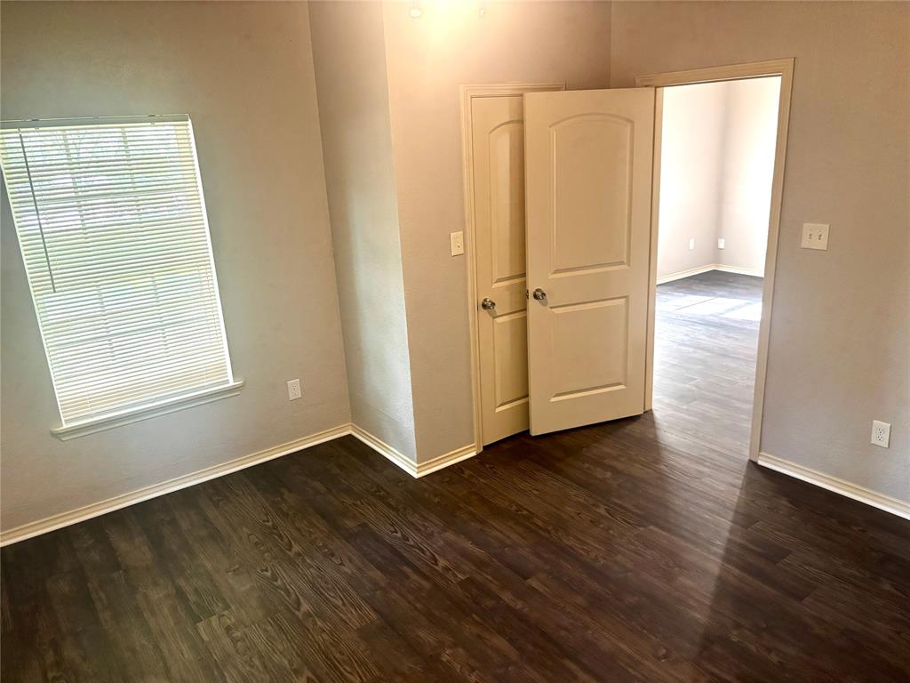 905 Isbell Road Fort Worth, TX 76114 - Photo 12 of 30 an empty room with wooden floor cabinet and windows