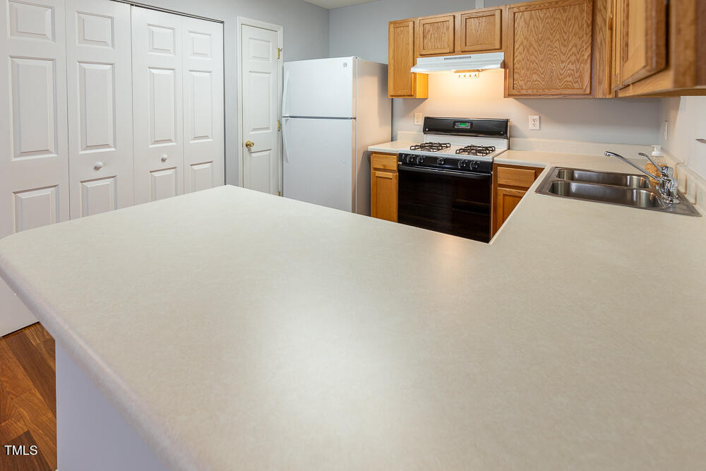 5420 Golden Moss Trail Raleigh, NC 27613 - Photo 10 of 33 a kitchen with cabinets and stainless steel appliances