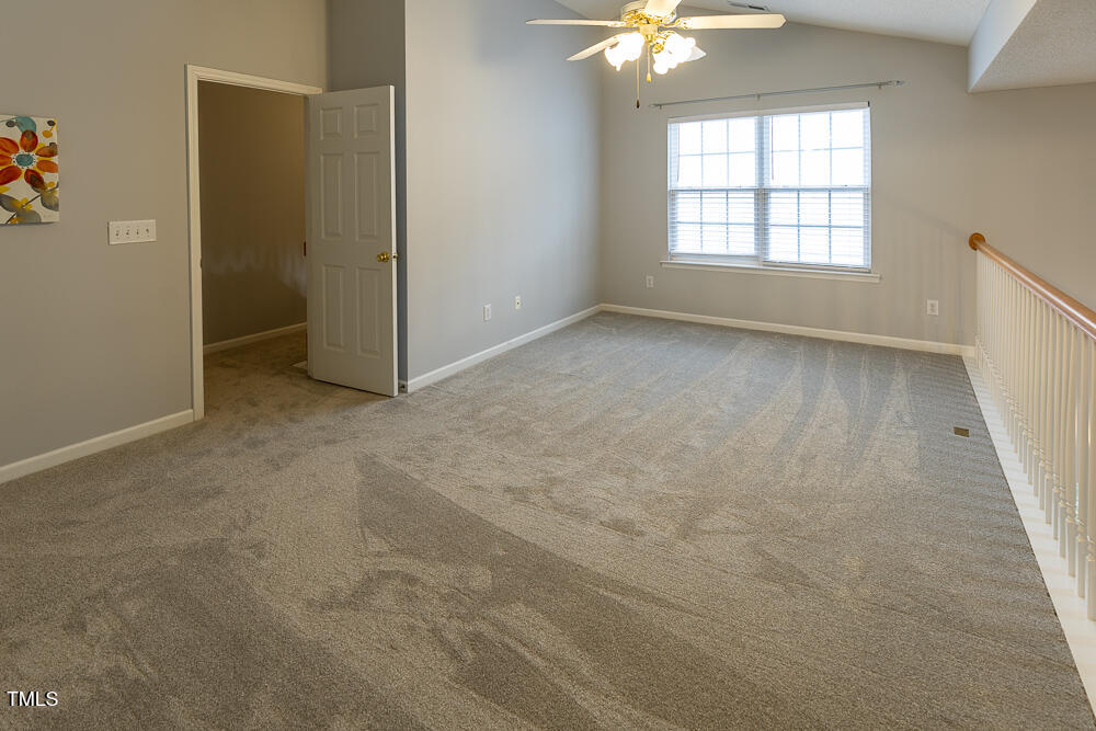 5420 Golden Moss Trail Raleigh, NC 27613 - Photo 24 of 33 an empty room with chandelier fan and windows