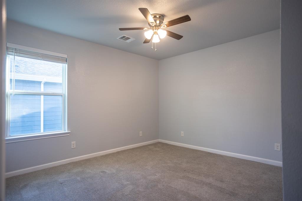815 Ritchey Street Gainesville, TX 76240 - Photo 11 of 18 an empty room with a window and a fan