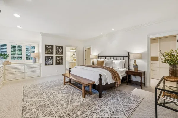 a spacious bedroom with a bed and wooden floor