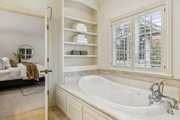 a bathroom with a tub sink and mirror