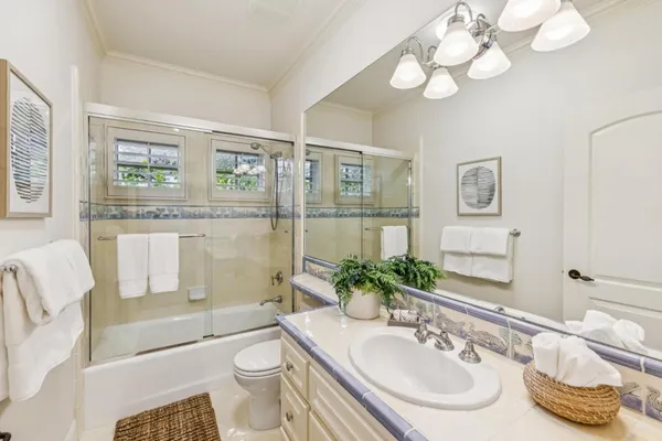 a bathroom with a granite countertop toilet sink and mirror