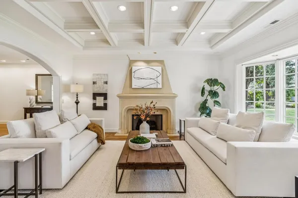 a living room with furniture a fireplace and a large window