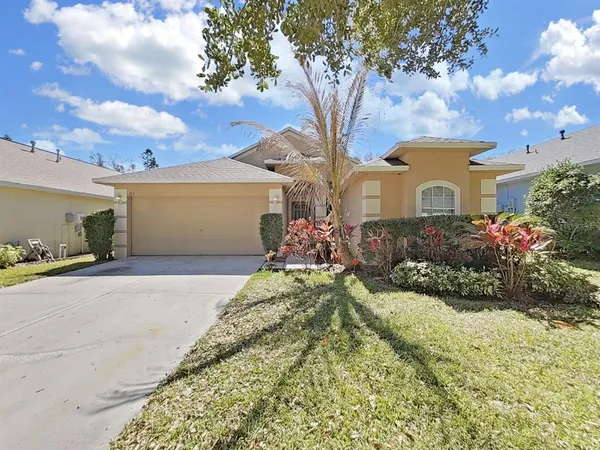 a front view of a house with a garden and trees