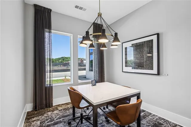 a dining room with wooden floor a chandelier a wooden table and chairs