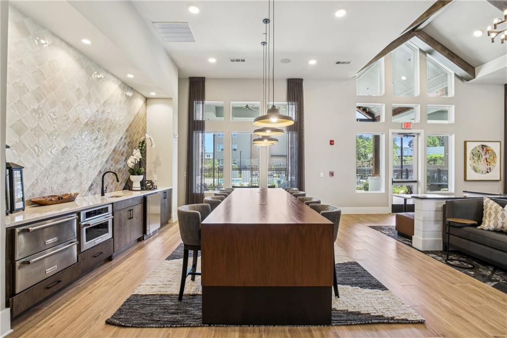 1296 Moreland Avenue Southeast, Unit 12101 Atlanta, GA 30316 - Photo 8 of 15 a living room with stainless steel appliances kitchen island granite countertop a stove a sink dishwasher and a dining table with wooden floor