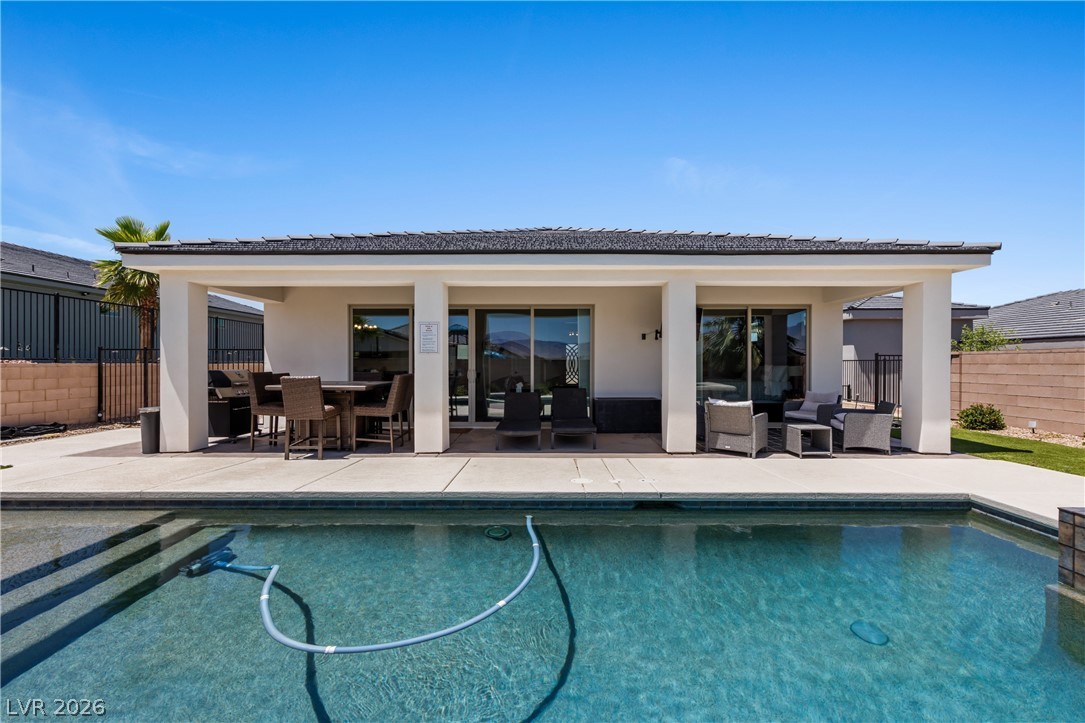 1436 Manassas Ridge Mesquite, NV 89027 - Photo 56 of 77 A sparkling pool invites relaxation, complementing the shaded patio for elegant outdoor living.