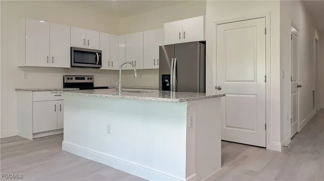 a kitchen with stainless steel appliances a refrigerator and a stove top oven