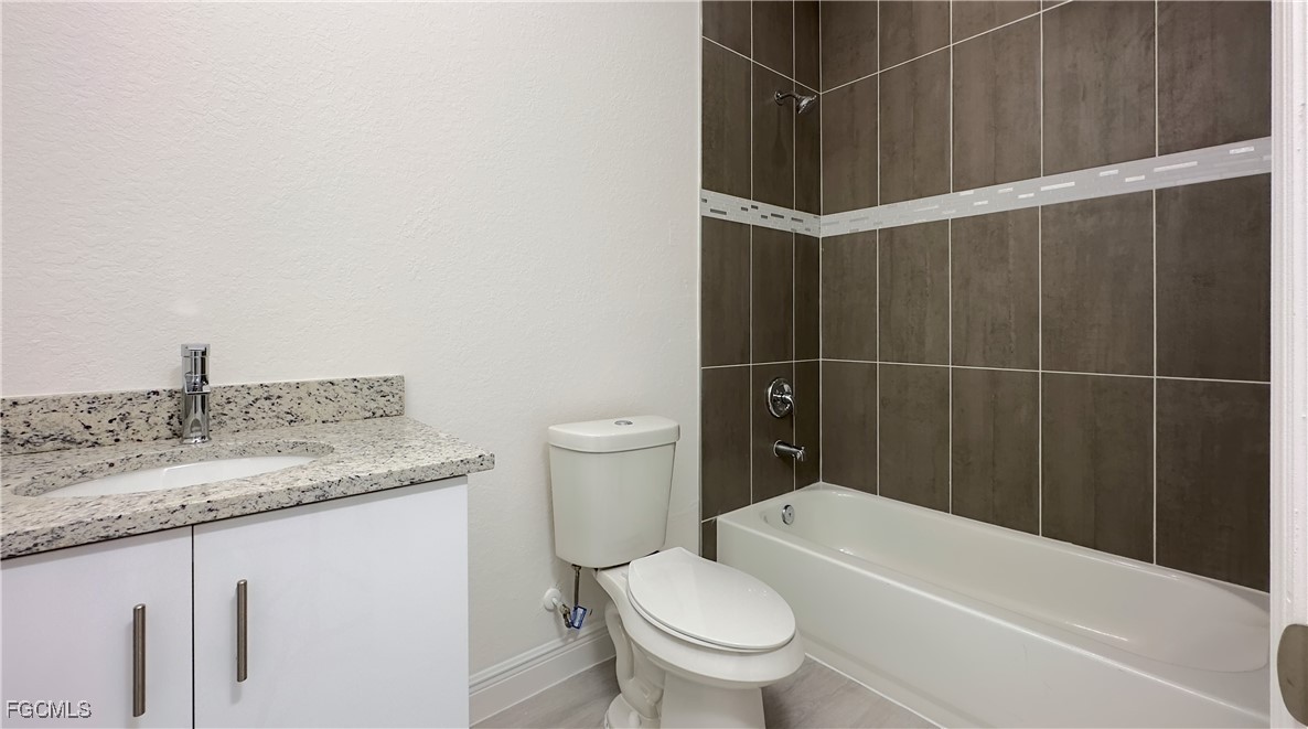 7005 Cape Court LaBelle, FL 33935 - Photo 7 of 9 a bathroom with a granite countertop sink toilet and shower