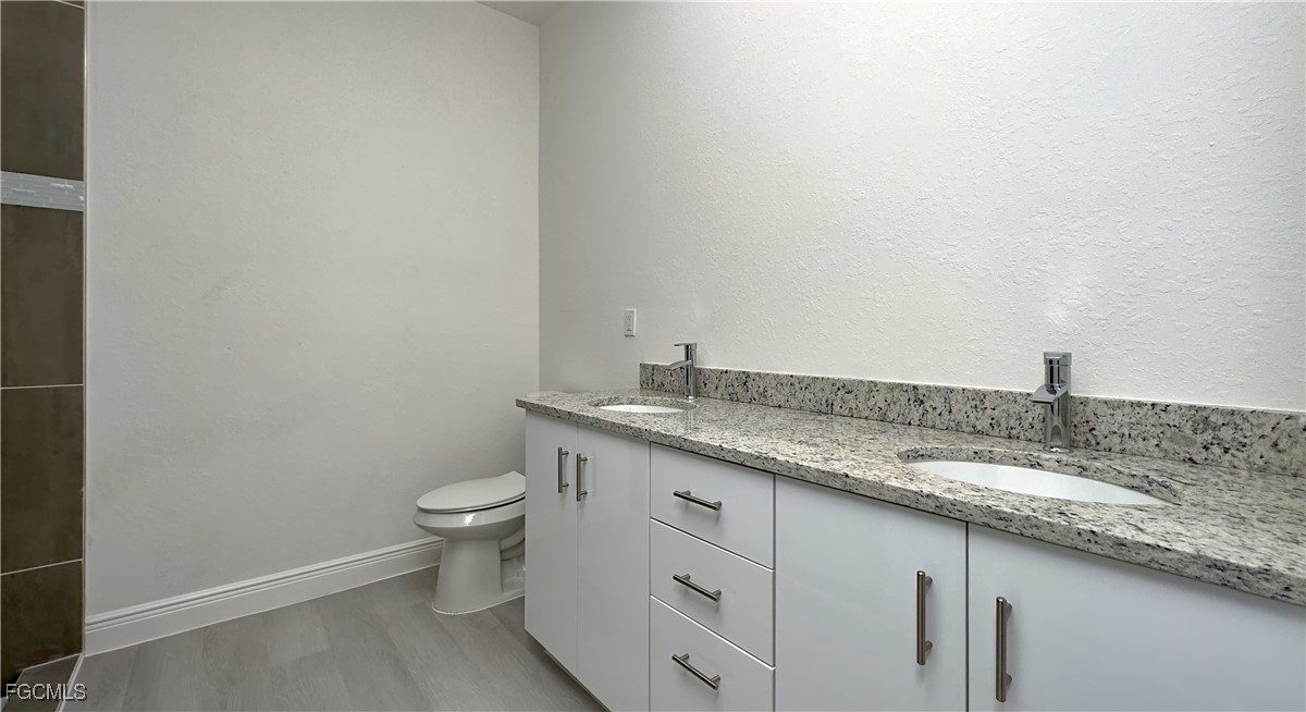 7005 Cape Court LaBelle, FL 33935 - Photo 8 of 9 a bathroom with a granite countertop sink and a toilet