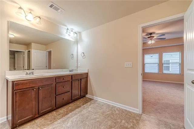 a spacious bathroom with a granite countertop sink a toilet and a mirror