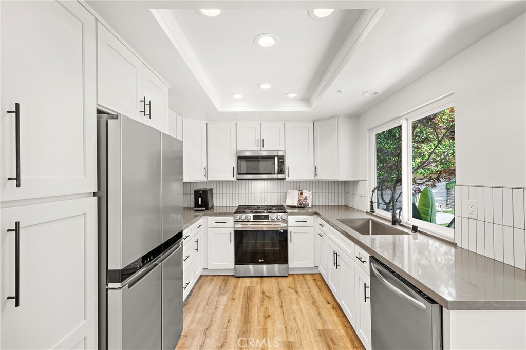 522 Calle Cuadra San Clemente, CA 92673 - Photo 15 of 37 a kitchen with a refrigerator a sink and wooden cabinets