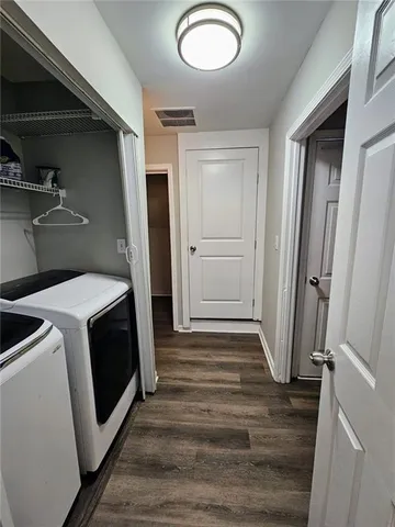 a view of a storage and utility room with wooden floor