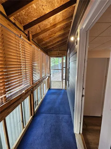 a view of a hallway with wooden floor and stairs