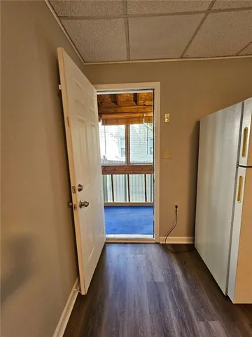 an empty room with wooden floor and a large window