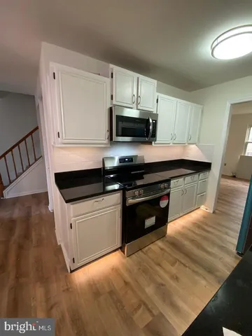 a kitchen with stainless steel appliances kitchen island granite countertop a stove a sink and a microwave