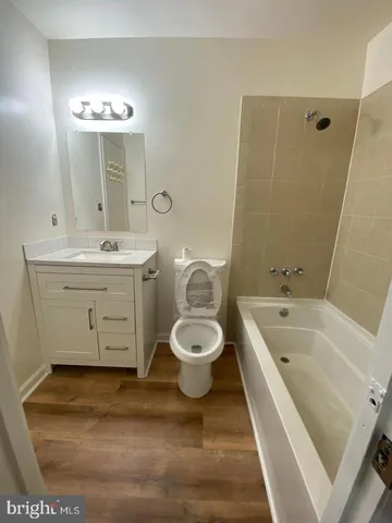 a bathroom with a granite countertop toilet a sink and a mirror