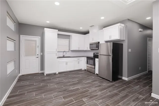 a kitchen with a refrigerator a sink and cabinets