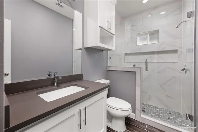 a bathroom with a granite countertop sink toilet and shower