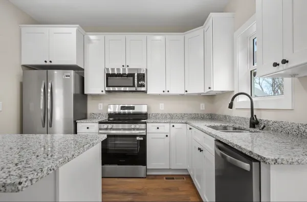 a kitchen with stainless steel appliances granite countertop a stove sink and refrigerator