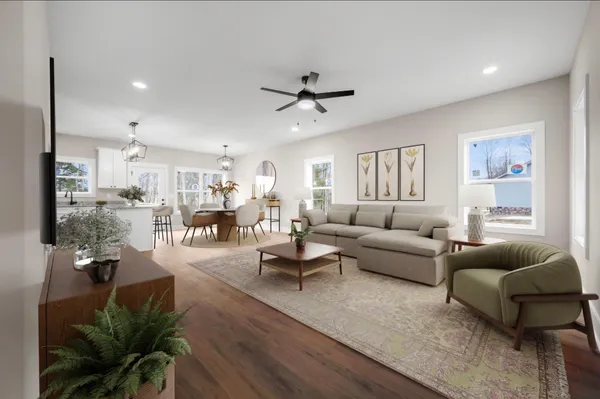 a living room with furniture kitchen view and a potted plant