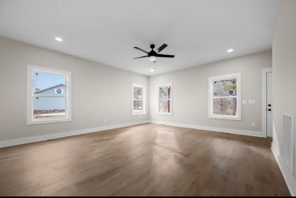 a view of an empty room with a window and a ceiling fan