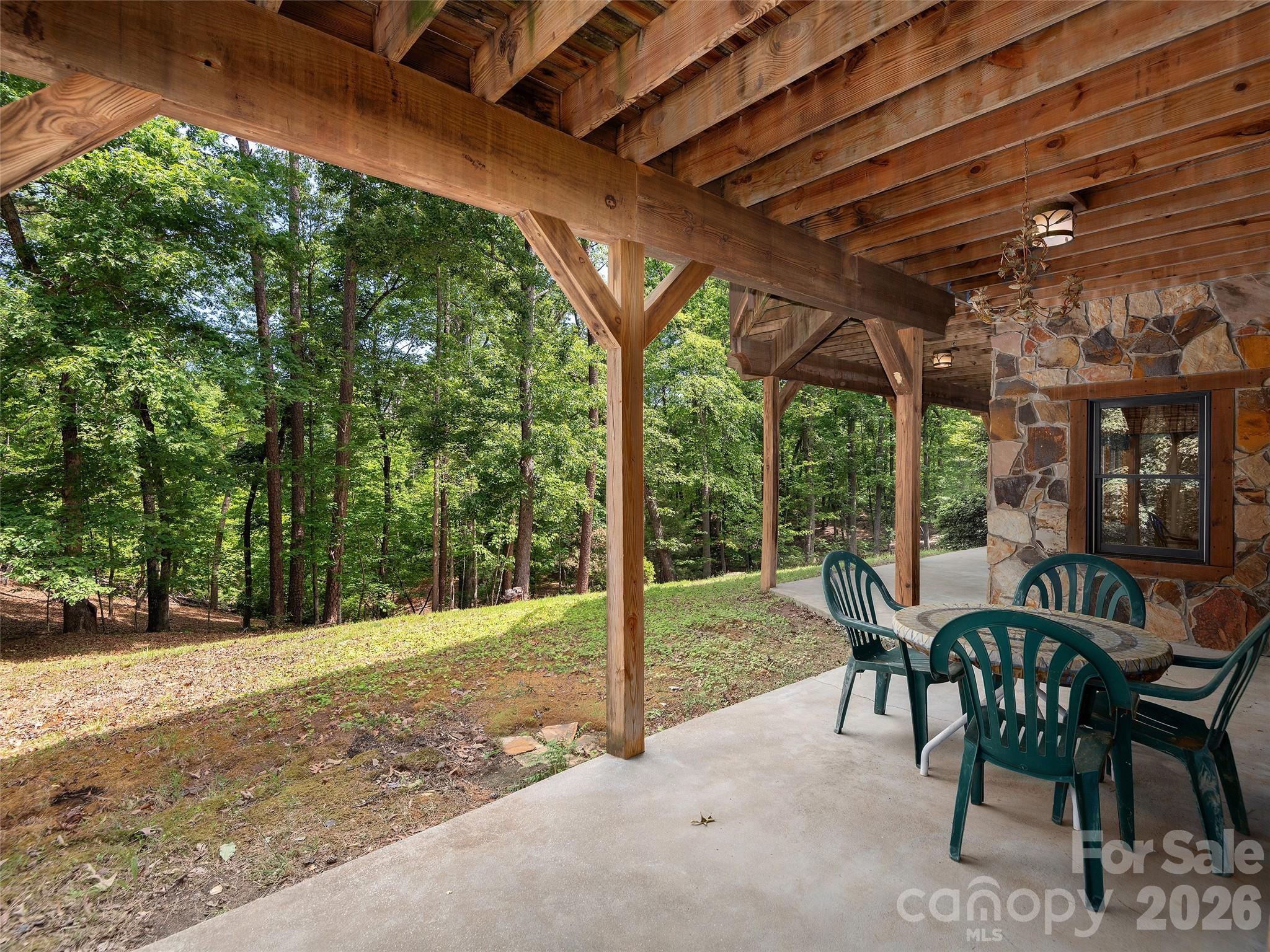 413 Green Hills Road Mill Spring, NC 28756 - Photo 42 of 48 a view of a patio with a table chairs and a backyard