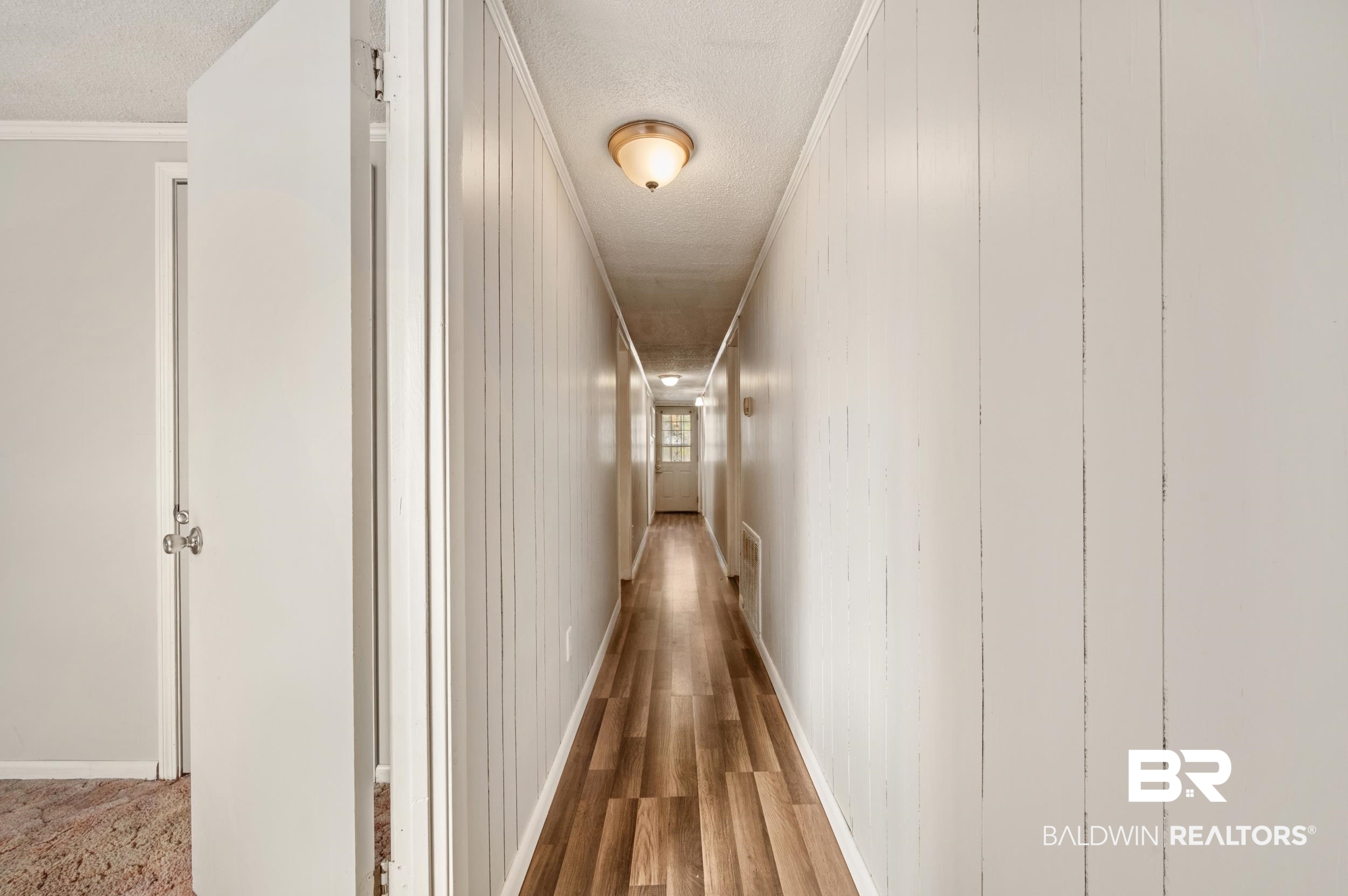 57623 Mary Hadley Road Perdido, AL 36562 - Photo 21 of 34 Hallway with ornamental molding, wood finished floors, and a textured ceiling