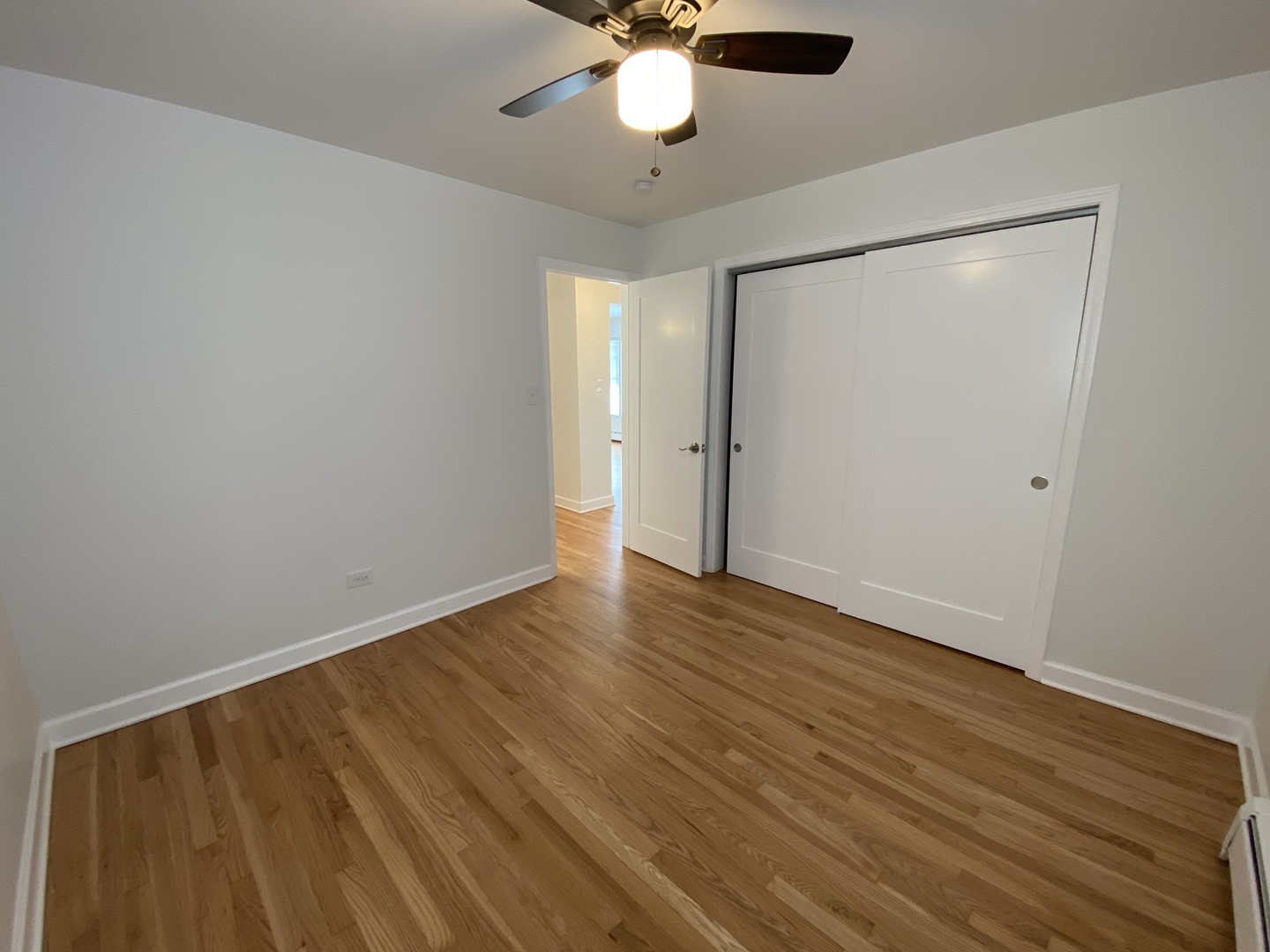 3146 Ridgeland Avenue, Unit 3W Berwyn, IL 60402 - Photo 8 of 16 a view of an empty room with wooden floor and a ceiling fan