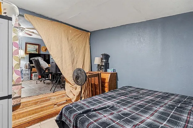 a bedroom with a bed and a dresser next to a window