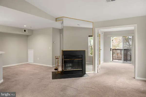 a view of an empty room with a fireplace and a window