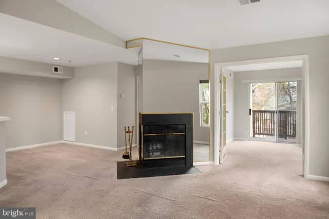 a view of an empty room with a fireplace and a window