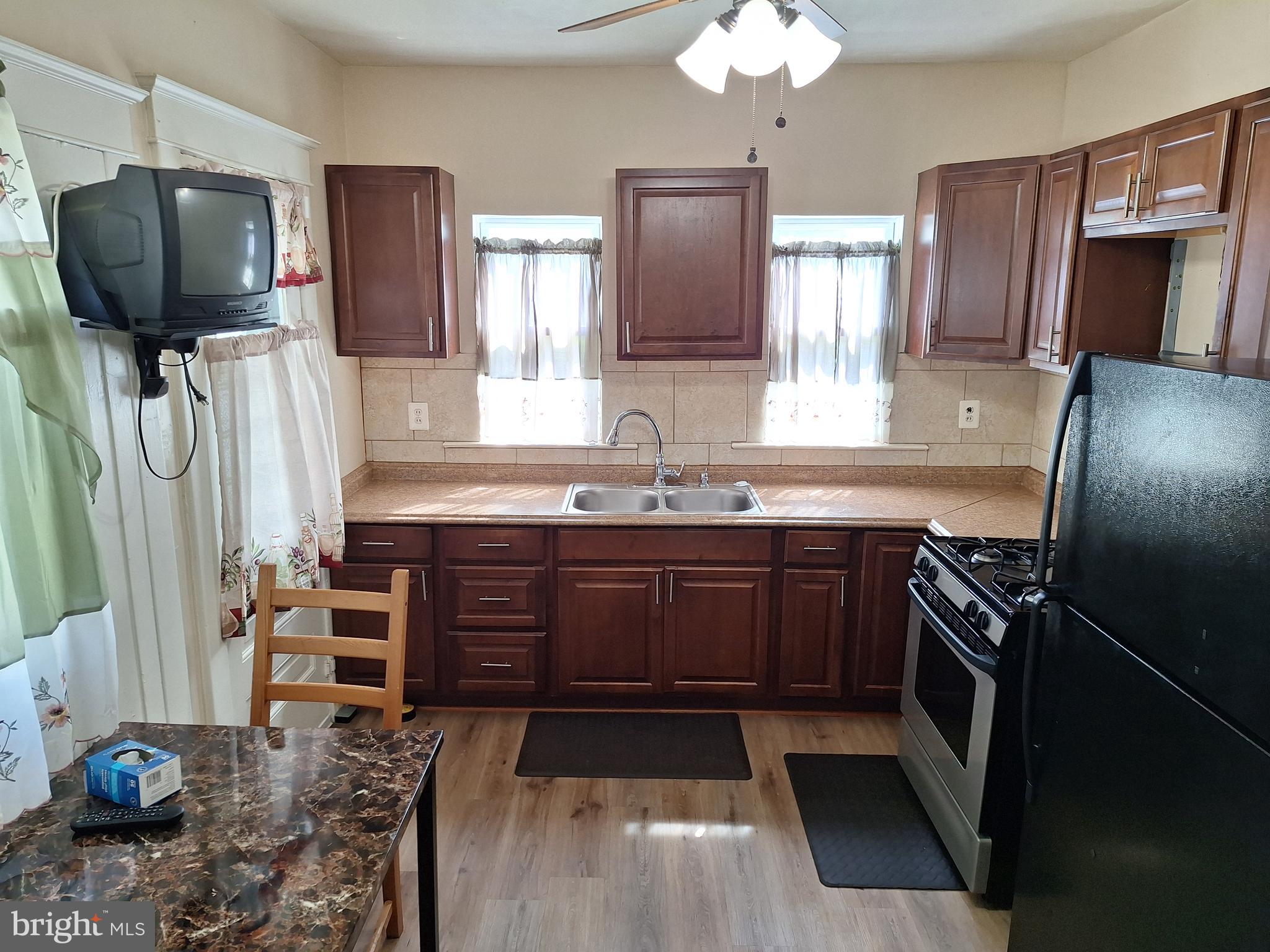 3803 Cedardale Road Baltimore, MD 21215 - Photo 25 of 56 a kitchen with stainless steel appliances granite countertop a stove refrigerator and microwave