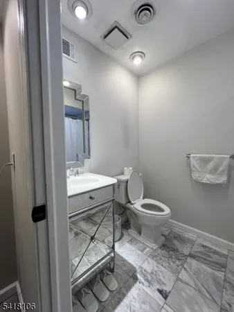 a bathroom with a toilet a sink and mirror
