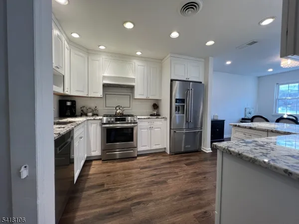 a kitchen with a refrigerator sink and cabinets