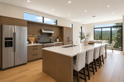 a kitchen with stainless steel appliances kitchen island granite countertop a stove a sink a refrigerator and a refrigerator