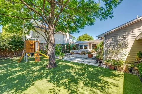 a view of a house with backyard and sitting area