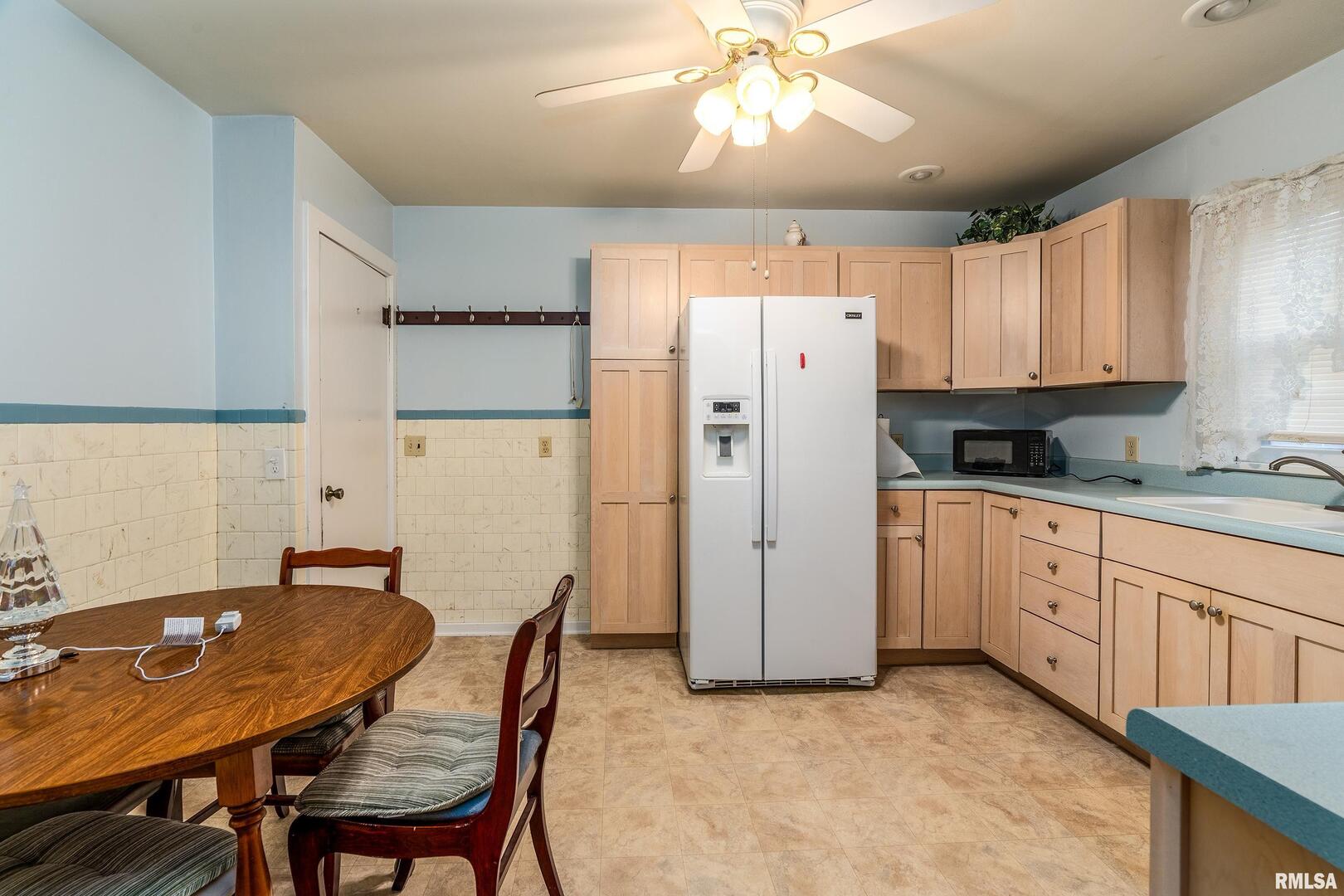2320 McCord Street Murphysboro, IL 62966 - Photo 11 of 27 a kitchen with stainless steel appliances granite countertop a refrigerator a sink a stove a dining table and chairs