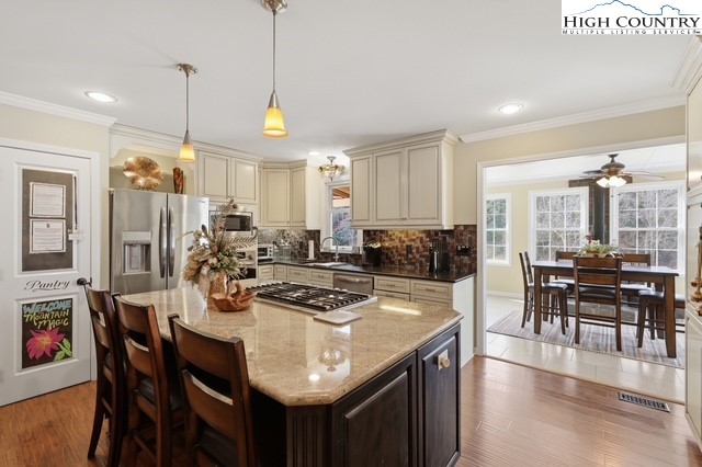 154 Beau Rivage Drive Crumpler, NC 28617 - Photo 28 of 34 a kitchen with stainless steel appliances granite countertop a stove a kitchen island a dining table and chairs