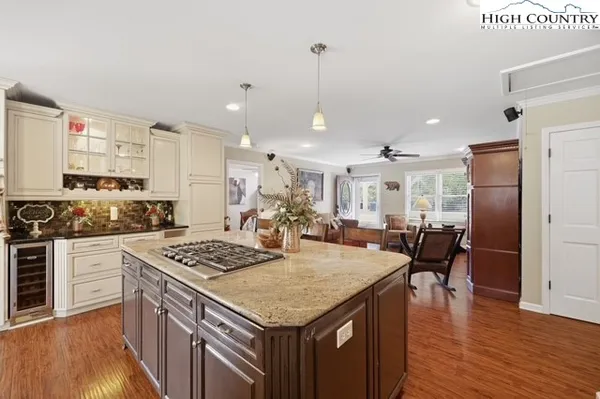 a kitchen with stainless steel appliances granite countertop a stove refrigerator and a wooden floor
