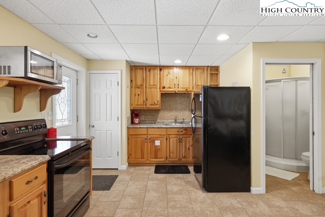 154 Beau Rivage Drive Crumpler, NC 28617 - Photo 31 of 34 a kitchen with granite countertop a refrigerator and a stove top oven