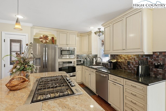 154 Beau Rivage Drive Crumpler, NC 28617 - Photo 7 of 34 a kitchen with stainless steel appliances a stove a sink cabinets and a wooden floor