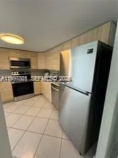 a kitchen with granite countertop a rug and white stainless steel appliances