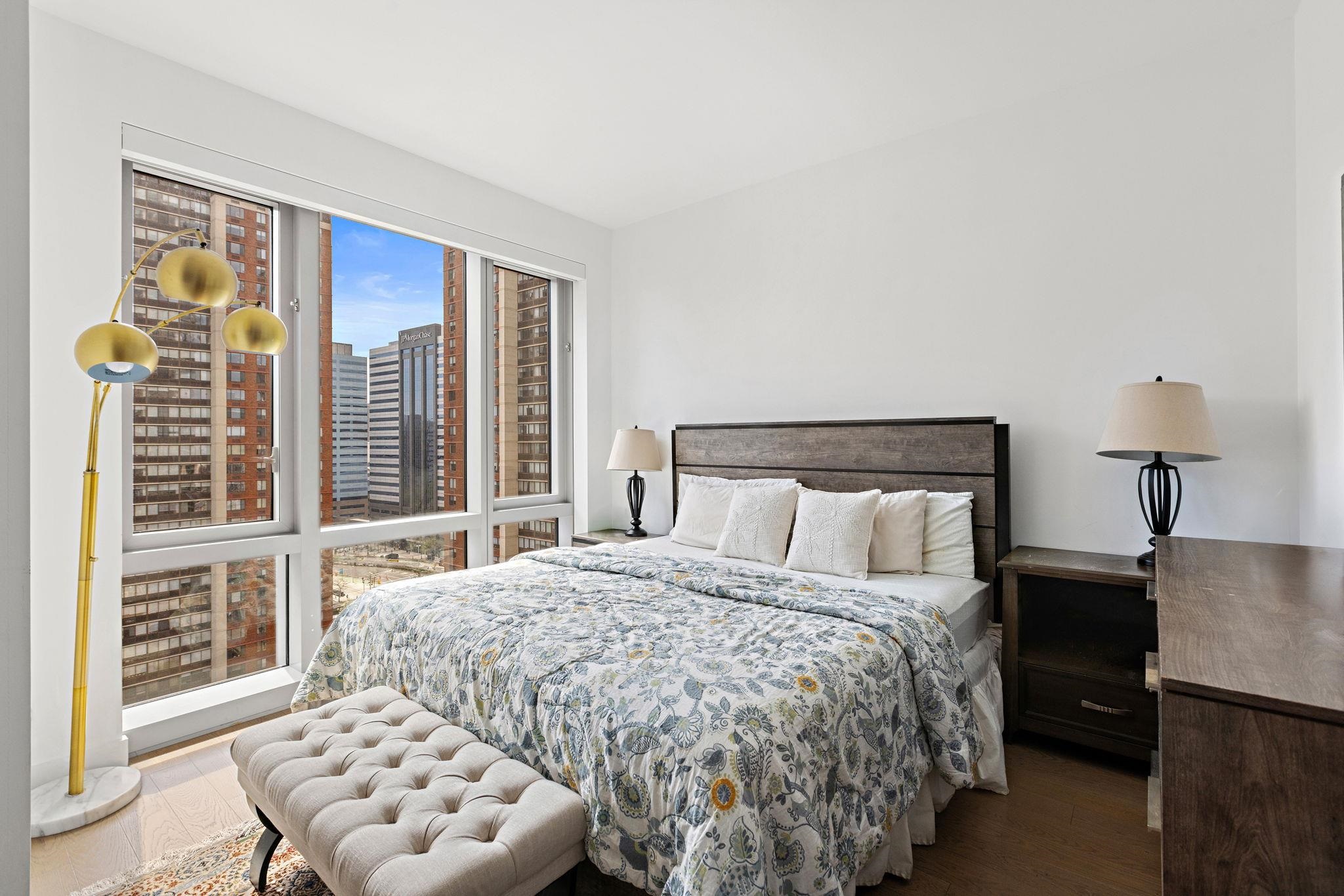 75 Park Lane South, Unit 1607 Jersey City, NJ 07310 - Photo 11 of 20 a bedroom with a bed and a window