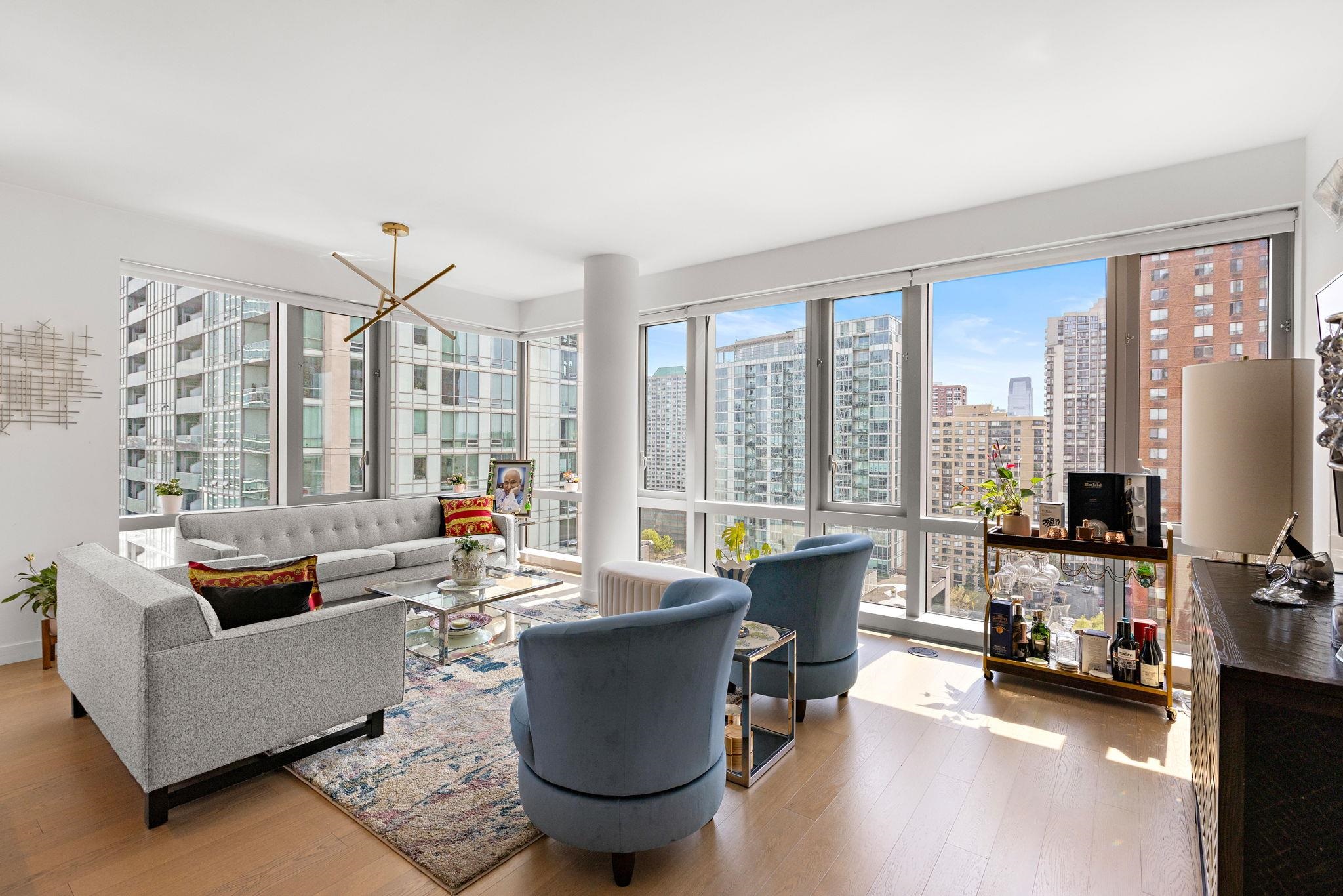 75 Park Lane South, Unit 1607 Jersey City, NJ 07310 - Photo 2 of 20 a living room with furniture and a large window