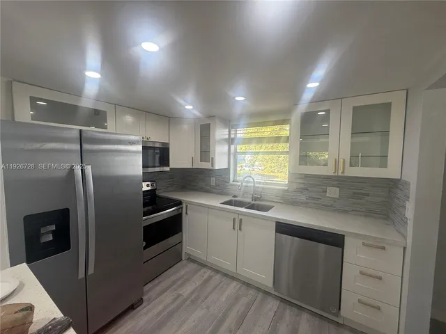 a kitchen with stainless steel appliances granite countertop a sink and refrigerator