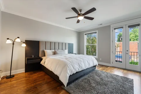a bedroom with a large bed and wooden floor